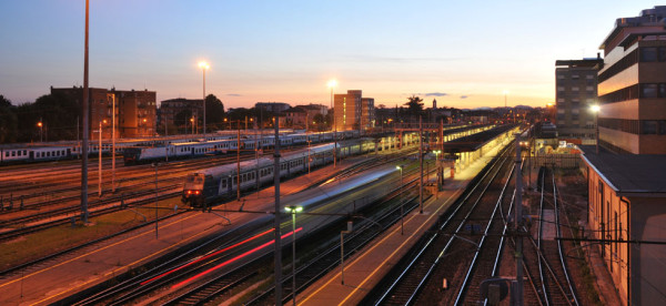 Brescia railroad station at dusk, a moving train is very motion blurred