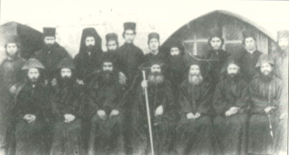 Σταυροβουνιώτες πατέρες (1913), ο ιερομόναχος Γρηγόριος καθήμενος αριστερά του ηγουμένου Βαρνάβα