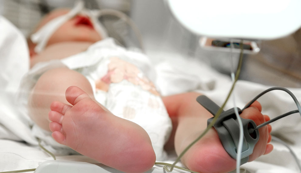 Close-up newborn baby foot in infant incubator