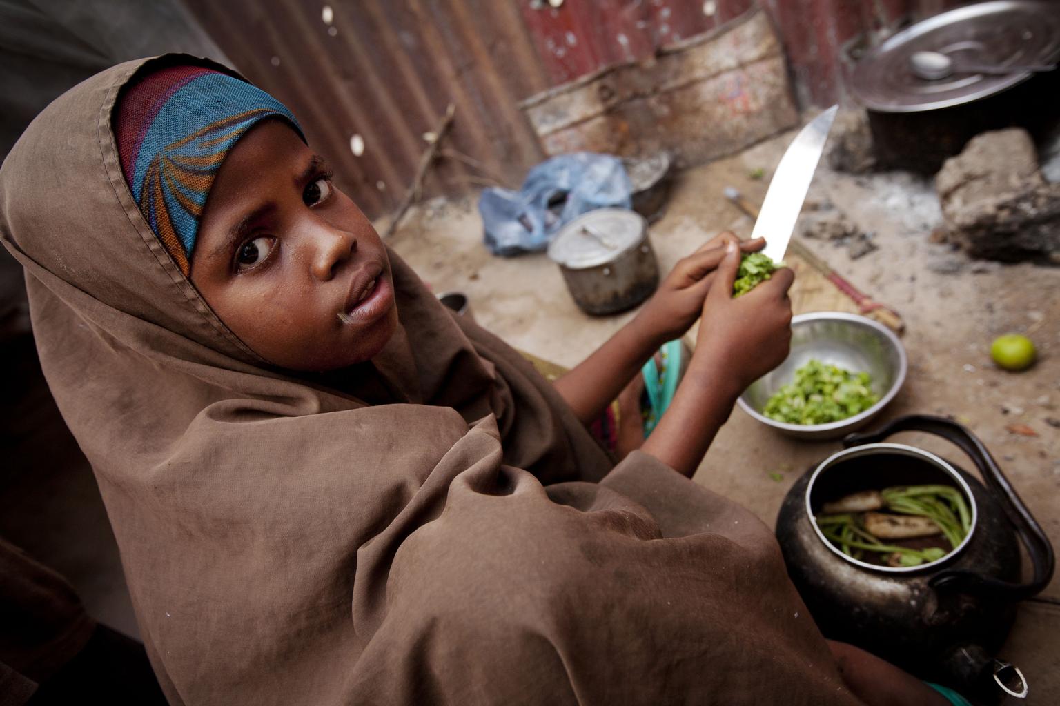 A girl helps prepare her familys evening meal, outside their makeshift home, in the Majo camp for displaced people, in Mogadishu, the capital. UNICEF, in partnership with Somali Community Concern, is supporting two schools, collectively serving over 800 children, in the camp. In July 2012, Somalia marked one year since famine was declared in parts of the country, amid the Horn of Africas worst drought in 60 years. While affected areas have since emerged from famine, conditions remain critical, and the countrys already decades-long conflict continues with no end in sight. A third of Somalis are currently in need of emergency assistance, and over one fifth of under-five children are suffering from malnutrition. By mid-June, over 992,000 Somalis had sought refuge in neighbouring countries, many of which are undergoing their own food crises, while 1.3 million had been internally displaced. Of these, over 127,000 have settled in war-torn Mogadishu, the capital. In the past year, UNICEF has treated over 455,000 acutely malnourished children under age 5; helped nearly 2.7 million people gain access to clean water and over 1.2 million to healthcare facilities; provided over 380,000 children with access to UNICEF-supported schools and over 37,000 to child-friendly spaces, where services include psychosocial assistance; and sent more than 27,000 tonnes of supplies to affected areas. UNICEF requires US$162.2 million for its ongoing work in Somalia throughout 2012, over 60 per cent of which remains unfunded.