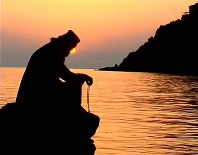 monk praying sunsetη...