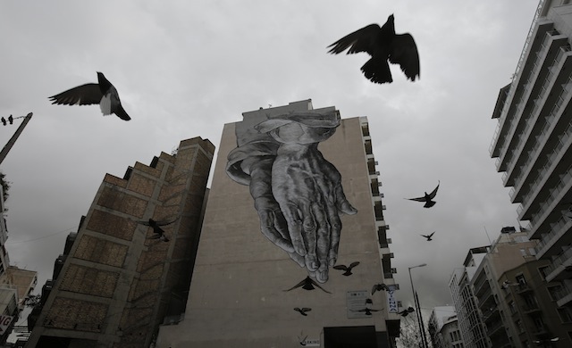 Περιστέρια πετούν γύρω από ένα κτίριο καλυμμένο με γκράφιτι στο κέντρο της Αθήνας, Τρίτη 24 Φεβρουαρίου 2015. Υπό αξιολόγηση βρίσκεται ο κατάλογος των μεταρρυθμίσεων που απέστειλε χθες αργά το βράδυ, αλλά εγκαίρως, η ελληνική κυβέρνηση, δήλωσε ο πρόεδρος του Eurogroup, μιλώντας στην Επιτροπή Οικονομικών και Νομισματικών Υποθέσεων του Ευρωπαϊκού Κοινοβουλίου σήμερα στις Βρυξέλλες. ΑΠΕ-ΜΠΕ/ΑΠΕ-ΜΠΕ/ΓΙΑΝΝΗΣ ΚΟΛΕΣΙΔΗΣ