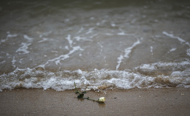 A rose is seen on the beach after being released by Thai children near a wave-shaped tsunami monument for victims of the 2004 tsunami in Ban Nam Khem