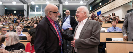 Peter Higgs & François Englert στην διάρκεια του σεμιναρίου όπου ανακοινώθηκε η ανακάλυψη του σωματιδίου Higgs. Οι δυο τους μαζί με τον Robert Brout είχαν προτείνει ήδη από το 1964 την ύπαρξη του σωματιδίου. O Robert Brout πέθανε το 2011 και δεν πρόλαβε να δει την πειραματική επιβεβαίωση του μηχανισμού