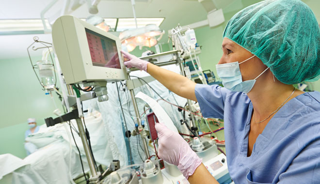 Surgery assistant nurse working with artificial cardiac valve at operation in cardiology clinic