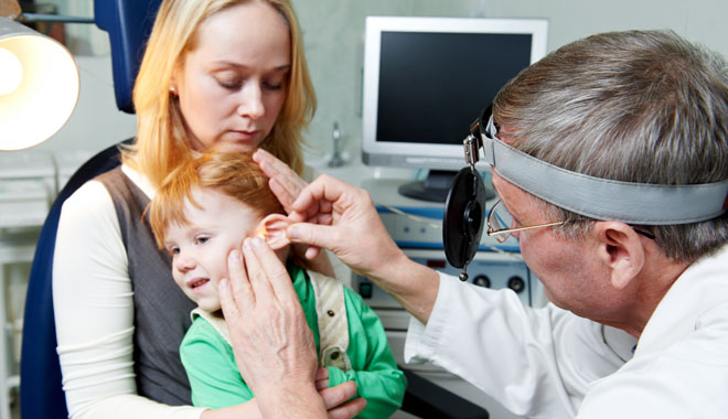 Medical otitus examination of a little child at a ear nose throat doctor