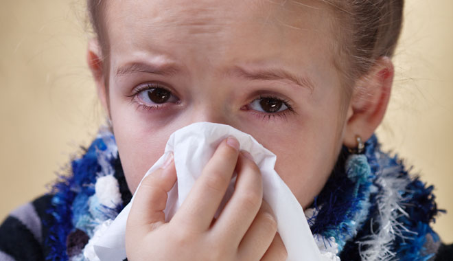 Little girl with red eyes got the flu - blowing her nose using paper napkin