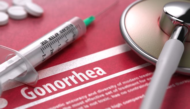 Gonorrhea - Medical Concept on Red Background with Blurred Text and Composition of Pills, Syringe and Stethoscope. 3D Render.