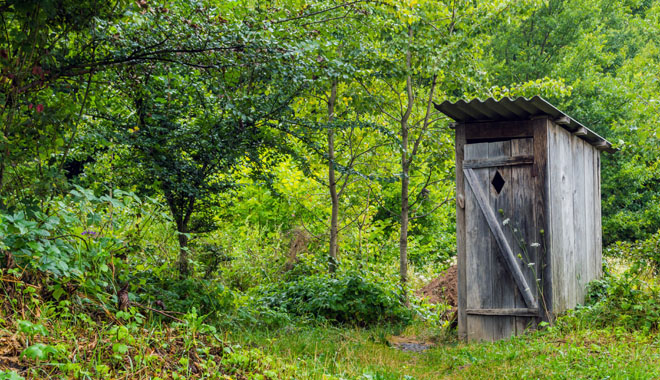 Old wooden toilet Camping in a village among the trees and bushes
