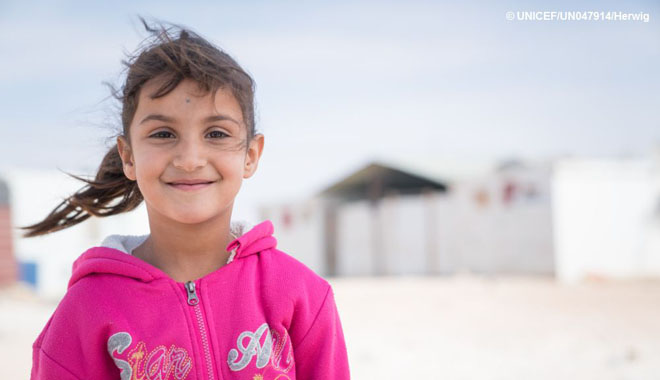 Syrian refugee Sidra, 7, stands outside her shelter in her new winter clothes, Za'atari refugee camp, Jordan, Wednesday, 23 November, 2016. Sidra's family received a winterization cash grant of 20 JOD per child from UNICEF earlier in the week and her mother went to the market to buy what she needed for the family. “Last year I had to go to the mall here in Za'atari to buy the clothes, but it was too crowded and too expensive, the clothes we bought were not nice,” says Sidra's mother Manar. “If you didn’t go at the beginning all the good things were gone. And the prices were too expensive; I could only buy one thing per child. The jumper that Lina is wearing, I bought it in the market this year for 3 JOD, last year in the mall it would have cost 10 JOD. “Last year as well, they didn’t give us cash, the money came on a card but the problem was that we could only use this card in the mall shops. We also had to spend the money in a set period of time, if you didn’t spend the money, you loose it. “But this year, I took the money from the NRC (Norwegian Refugee Council) and UNICEF, and I went to the market. I bought clothes for my elder son, and all the rest of my children, from 16 years old and under, it was so much cheaper. The pyjamas that cost 10 JOD in the mall, I found them for 5 JOD. I have spent 70 JOD on Sunday and today I hope to spend the rest. “The shops here today they are full of people buying clothes for winter because this as an idea is really good, it’s not tied to something, you’re not limited to the mall and you also don’t loose the money if you don’t spend it. You have the money in your pocket at any hour or time. You are not tied to go to a specific place, you can buy socks, boots, trousers, clothes, anything, everything; you have a choice. “I have spent all the money on warm clothes for winter, because this money came for the winter clothes, so I bought winter clothes for my children. It is important that my child