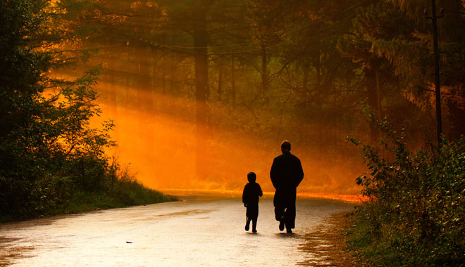 father and son walking in the sunlight